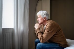 Older adult sitting alone at home appearing withdrawn and fatigued, illustrating subtle signs of depression in seniors.