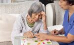 Older adult with Alzheimer’s receiving compassionate in-home care through the NHTD Waiver Program, promoting independence and quality of life.