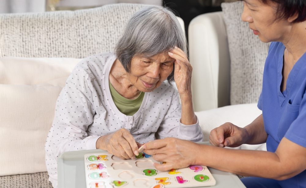 Older adult with Alzheimer’s receiving compassionate in-home care through the NHTD Waiver Program, promoting independence and quality of life.