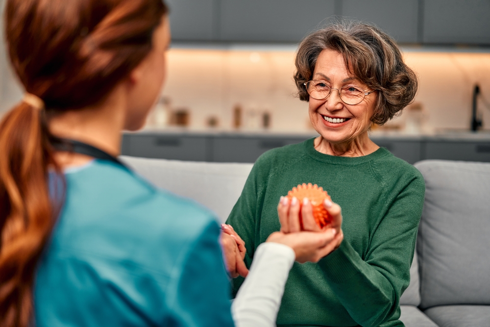Senior stroke survivor practicing mobility exercises with a home health caregiver during rehabilitation at home.