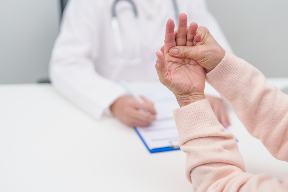 Neurologist evaluating senior patient with Parkinson’s disease symptoms during an in-home medical visit