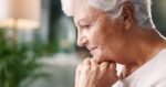 Senior caregiver comforting an elderly woman showing signs of emotional distress and behavioral health changes at home.